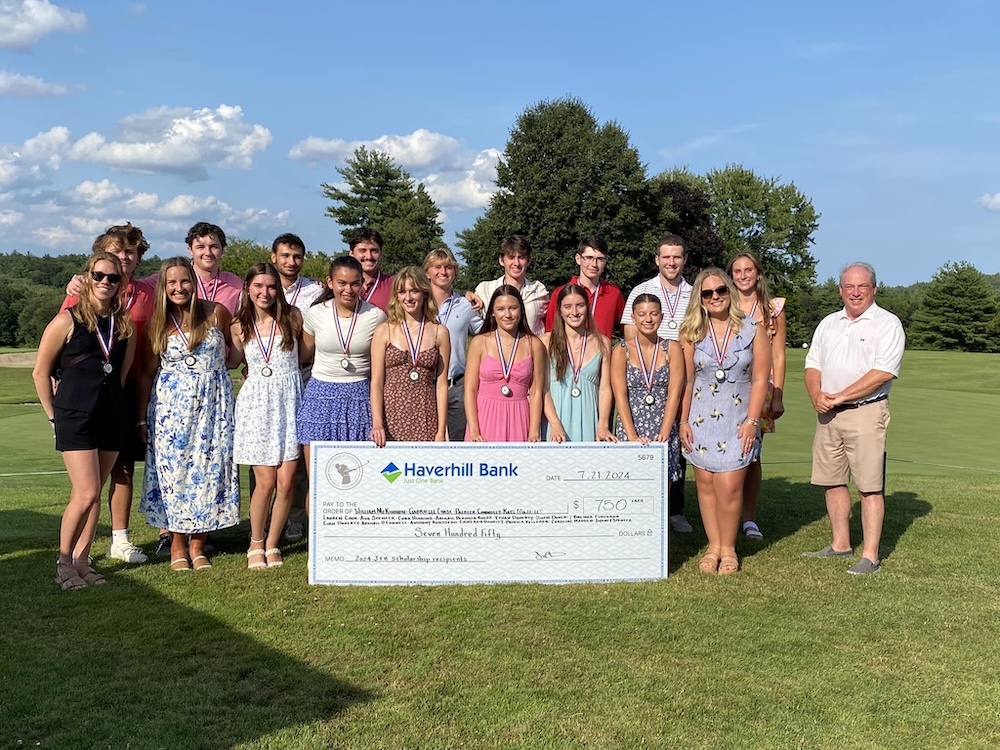 Scholarship recipients pictured with a big check and bank team.